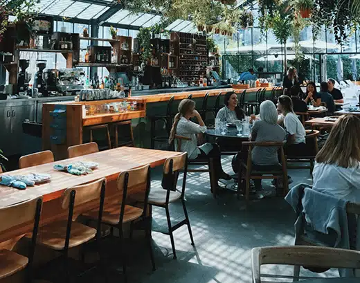 Salle lumineuse du restaurant La Table de 3 à Bordeaux, avec clients attablés en pleine discussion